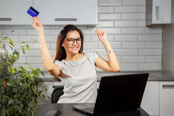 Mujer feliz haciendo compras en línea desde casa con tarjeta de crédito y portátil. Alegría después de compras . — Foto de Stock