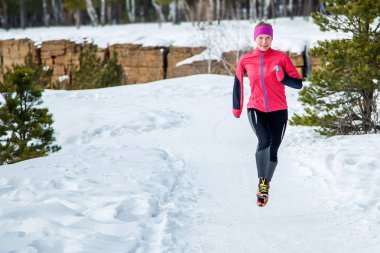 Spor kadın çalışıyor. Kadın atlet sıcak sportif çalışan giysiler giyiyor soğuk kış ormanda koşu. Kış Park'ta koşan fitness mutlu kız. Fitness ve sağlıklı yaşam konsepti