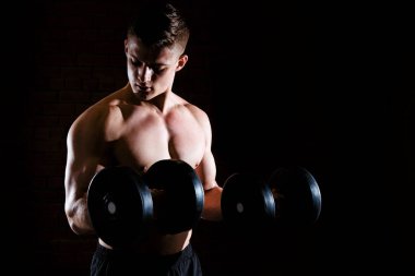 Yakın çekim yakışıklı güç atletik biri dumbbells ile kas pompalama eğitim
