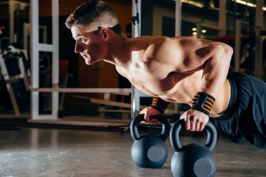 Kasları eğitim şınav dambıl bir spor salonunda üzerinde vücut geliştirme egzersiz olarak güçlü yakışıklı adam