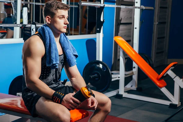 Şişe su ve spor olarak çalışma sonra molası havlu ile yakışıklı adam.