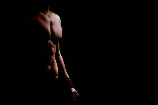 Silhueta de close-up de um torso atlético e mãos de um homem em um fundo escuro — Fotografia de Stock