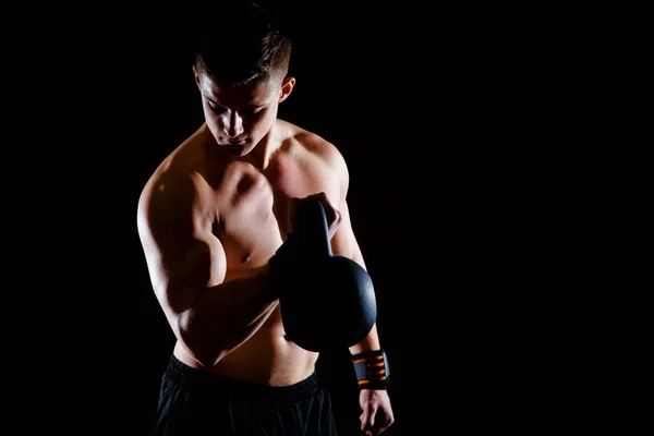 Colpo di sano muscolare giovane che fa esercizio di peso con manubri sullo sfondo scuro. Culturista che fa allenamento con pesi pesanti per bicipiti . — Foto Stock