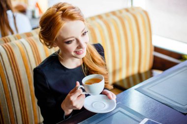 Bir kafede yeşil çay içme ve gülümseyen genç mutlu kadın