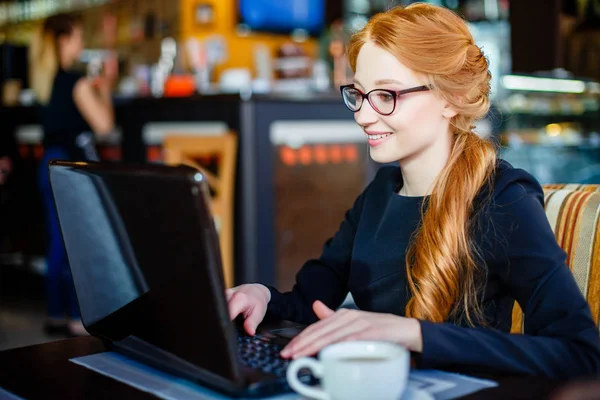 Портрет успешной молодой женщины с ноутбуком в кафе — стоковое фото