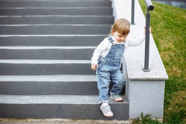 A small child learns to go down the stairs clipart