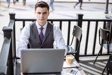 Yakışıklı işadamı city café'de dizüstü bilgisayar kullanarak.