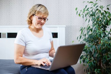 Gülümseyen kadın kıdemli laptop evde çalışma