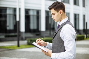 Notlar açık havada zeki erkek öğrenci