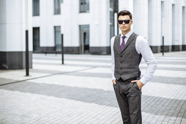 Деловой человек в солнечных очках на открытом воздухе в городе

