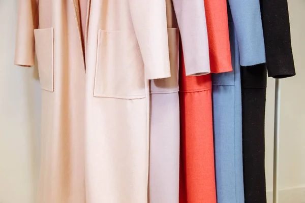 Смешать цветной ряд женских пальто на вешалках — стоковое фото