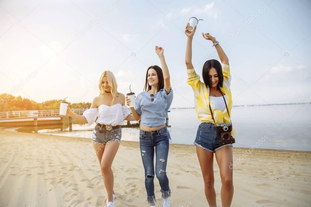 Summer vacation, holidays, travel and people concept - group of smiling young women dancing on beach