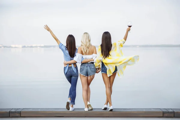 A picture of three young happy women in the summer. The view from the back. — Stock Photo, Image