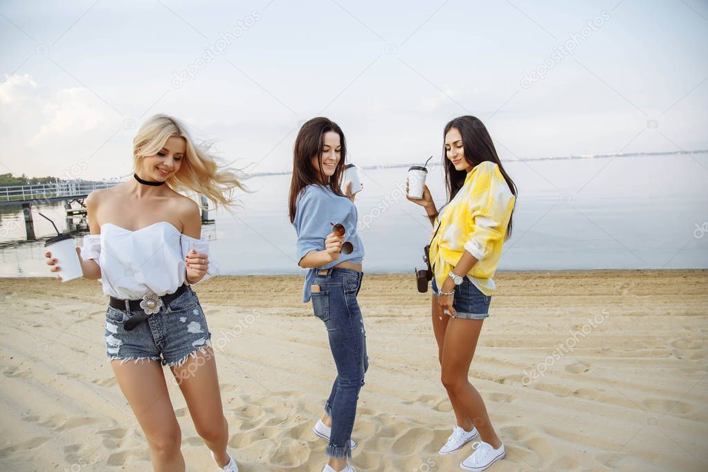 Vacation. Beach Party. Group of happy young women dancing at the beach on summer sunset. 