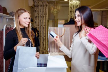 Mutlu bir kadın müşteri moda salonu kredi kartı ile ödeme