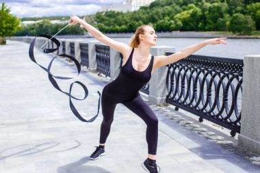 Genç kız ile kurdele açık Ritmik Jimnastik egzersizleri yapıyor