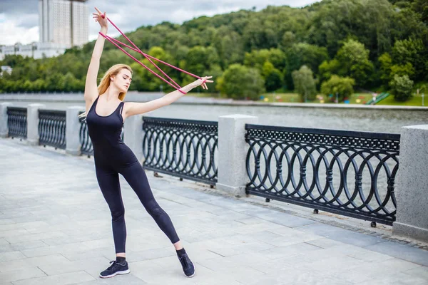 Genç güzel kız açık havada jimnastik egzersizleri yapıyor