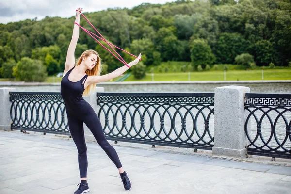 Young beautiful girl doing gymnastic exercises outdoors — Stock Photo, Image