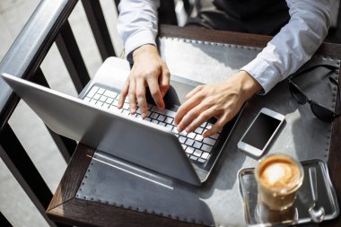 Başarılı yönetici kafede break ve Internet arama bilgilerinde kendi dizüstü bilgisayarında sırasında erkek el laptop modern kahve dükkanı veya çatı kullanarak çalışma