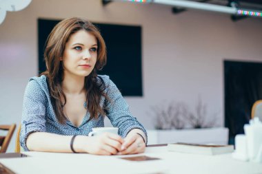 Genç çekici kız bir şehir kafede kahve içecekler