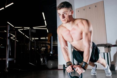 Kasları eğitim şınav dambıl bir spor salonunda üzerinde vücut geliştirme egzersiz olarak güçlü yakışıklı adam