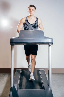 Kardiyo egzersizleri, spor salonunda koşu bandı üzerinde çalışan yapan yakışıklı erkek