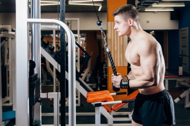 Vücut geliştirmeci yapıyor ağır ağırlık egzersiz Triceps ile tel kablo için jimnastik salonu