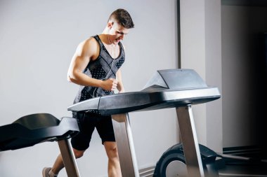 Spor Kulübü koşu bandı üzerinde çalışan kulaklıklar ile yakışıklı adam