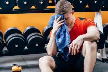 Yorgun genç atletik erkek eğitimden sonra biraz ara. Fitness, spor ve yaşam tarzı kavramı.