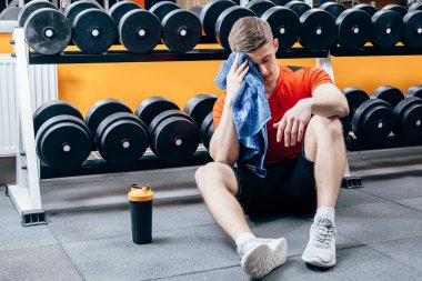 Şişe su ve spor olarak çalışma sonra molası havlu ile yakışıklı adam.