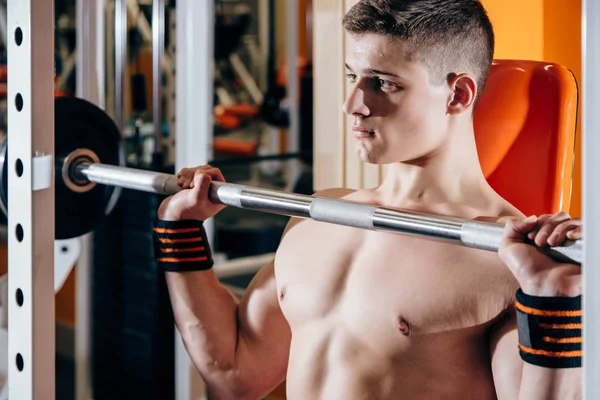 Kadar bir halter salonunda, çalışma genç yakışıklı beyaz vücut geliştirmeci sporcu pazı eğitim yaparken kapatın