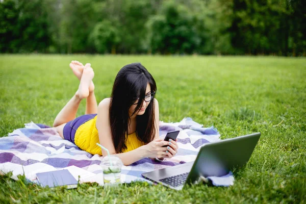 Молодая женщина работает на ноутбуке на открытом воздухе — стоковое фото