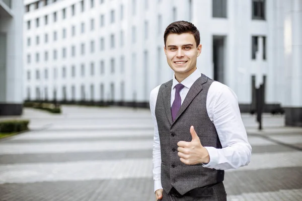 Молодой бизнесмен показывает большой палец и улыбается — стоковое фото