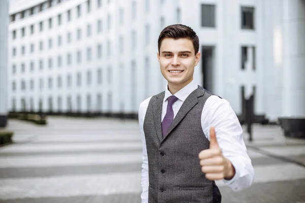 Young business man showing thumb up and smiling