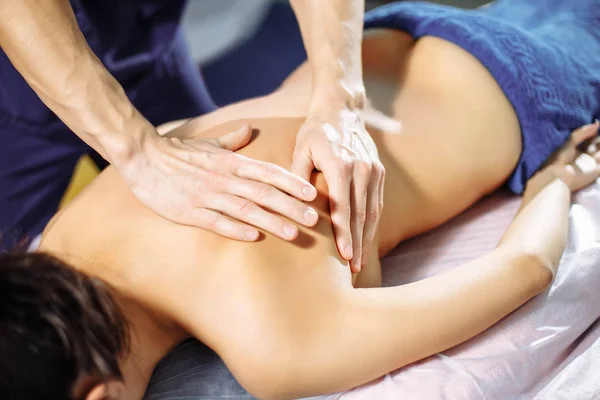 Closeup of male hands of massage therapist massaging woman's back Royalty Free Stock Photos