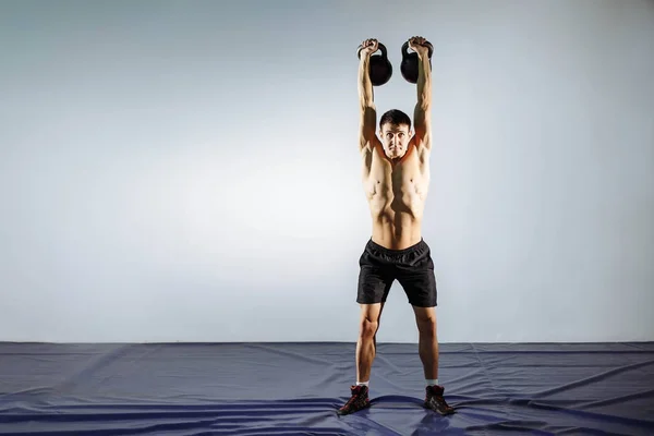 Мускулистый молодой человек делает тяжелые упражнения для бицепсов . — стоковое фото