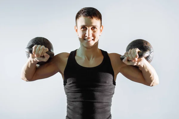 Retrato de un hombre musculoso sonriente realizando ejercicios con pesas . —  Fotos de Stock