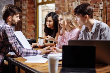Bir grup genç yaratıcı insan yeni bir proje tartışıyor.