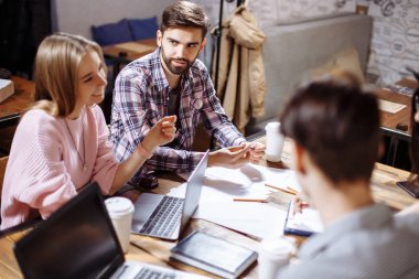 Bir grup genç insan bir kafede seminer için hazırlanıyor.