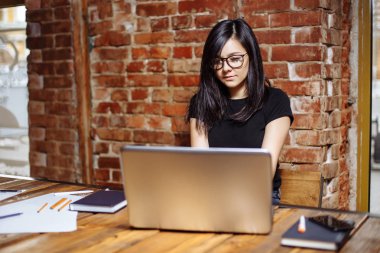 Kafede dizüstü bilgisayarda çalışan genç güzel kadın