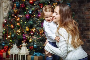 Mutlu aile anne ve kızı yılbaşı ağacının yanında sarılma.