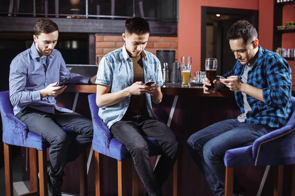Concept de personnes, d'hommes, de loisirs, d'amitié et de technologie - amis masculins avec smartphones buvant de la bière au bar ou au pub . — Photo