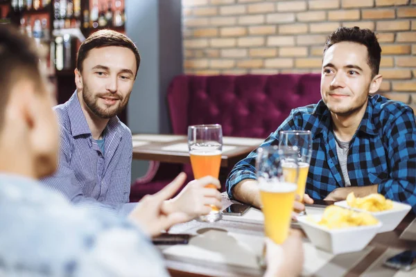 Люди, мужчины, отдых, дружба и концепция празднования - счастливые друзья-мужчины разговаривают и пьют пиво в баре или пабе . — стоковое фото