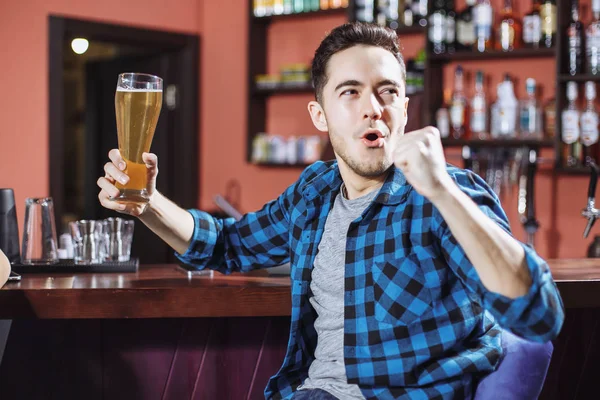 Emocionální mladý muž s pivo v baru — Stock fotografie