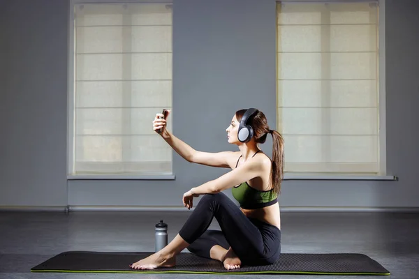 Chica atractiva haciendo una selfie después de hacer ejercicio en el gimnasio . — Foto de Stock