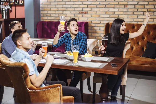 Amis heureux ayant des loisirs dans le pub regarder le sport à la télévision ensemble boire de la bière . — Photo