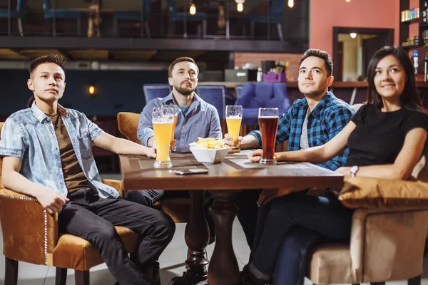 Amigos felizes tendo lazer no pub assistindo esporte na TV juntos bebendo cerveja . — Fotografia de Stock