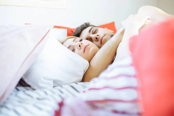 Persone, famiglia, ora di andare a letto e concetto di felicità - coppia felice che dorme e si abbraccia a letto a casa . — Foto Stock