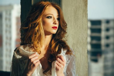 Pencerenin yanında çekici bir genç kadın portresi