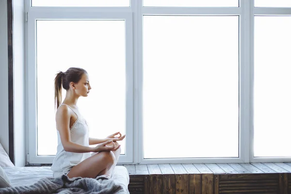 Jovem mulher esportiva praticando ioga em casa quarto depois de acordar — Fotografia de Stock